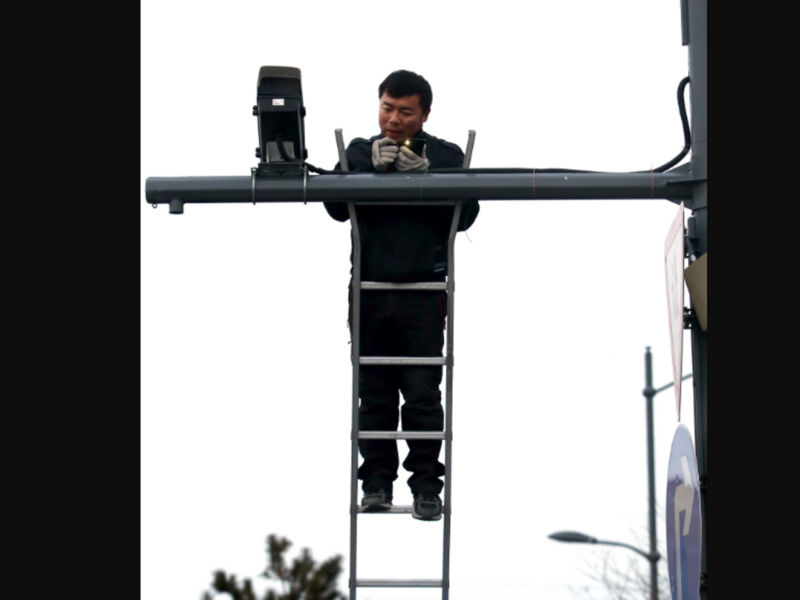 photo of a man on a ladder installing a cctv camera