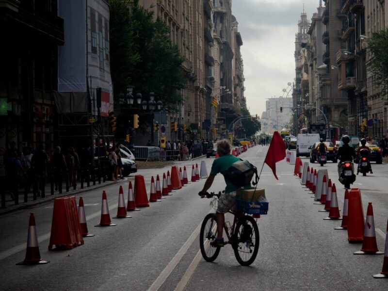 Photo of a man riding a bicycle in a lane reserved for cyclists.