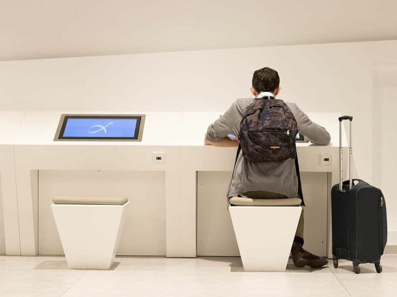 Photo of a man sitting donw with his luggage at Athens' airport