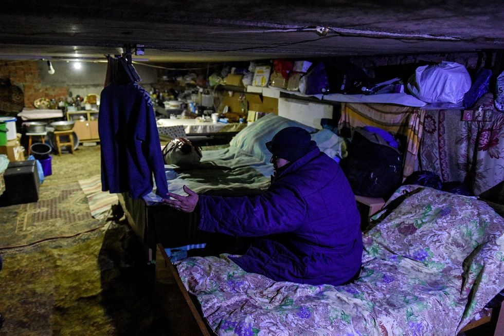 Photo of a man sitting on a bed in one of the basements.