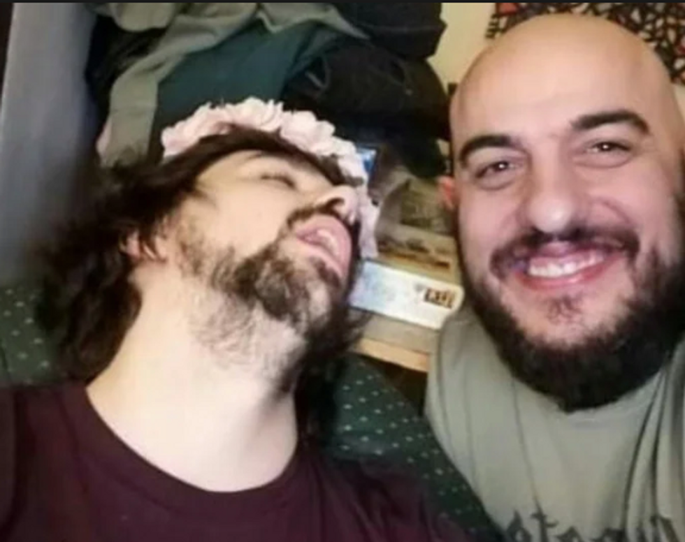 Photo of a man sleeping with a friend smiling next to him