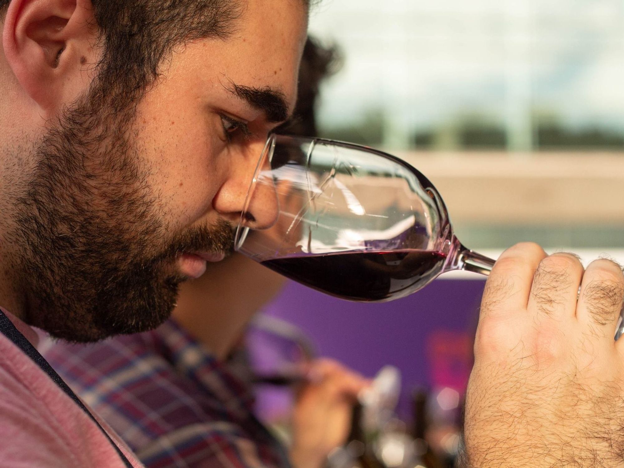 Photo of a man smelling a glass of red wine