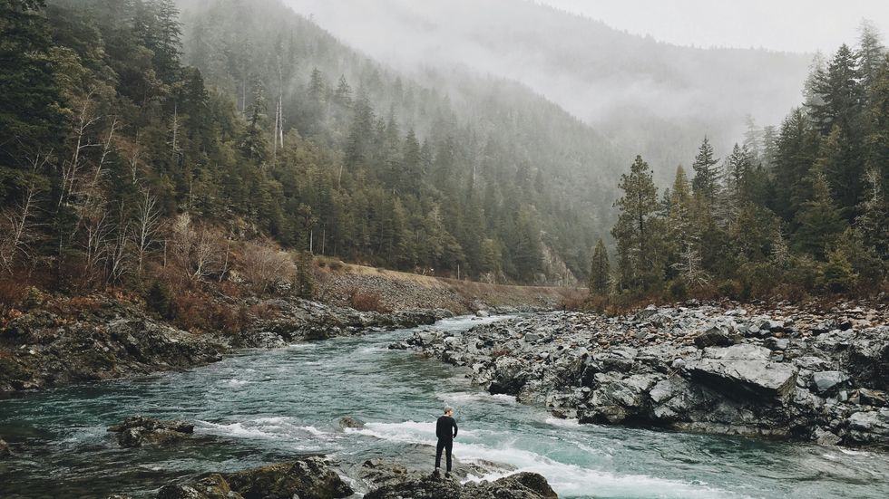 photo of a man standing by a river