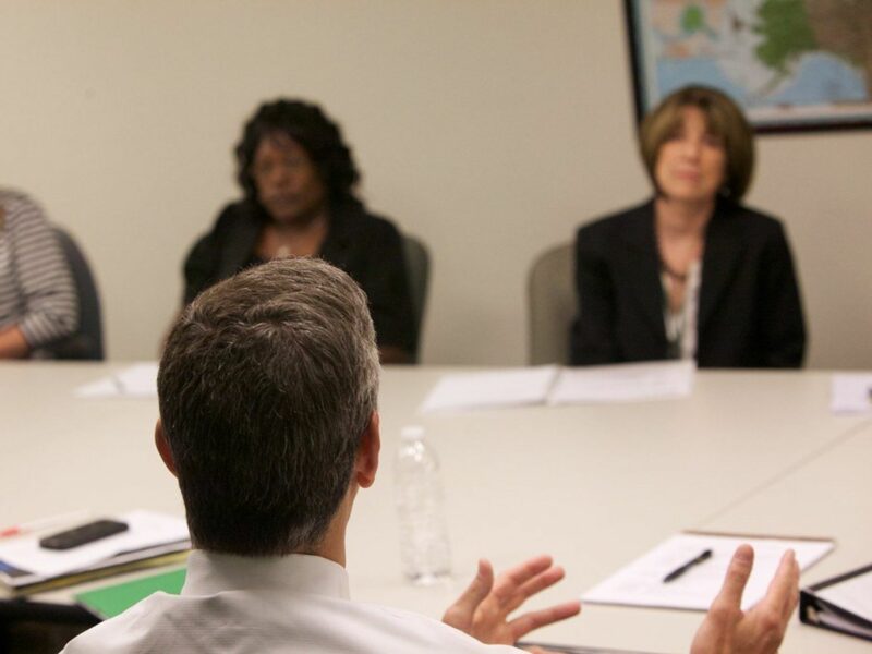 photo of a man talking to three women across a table