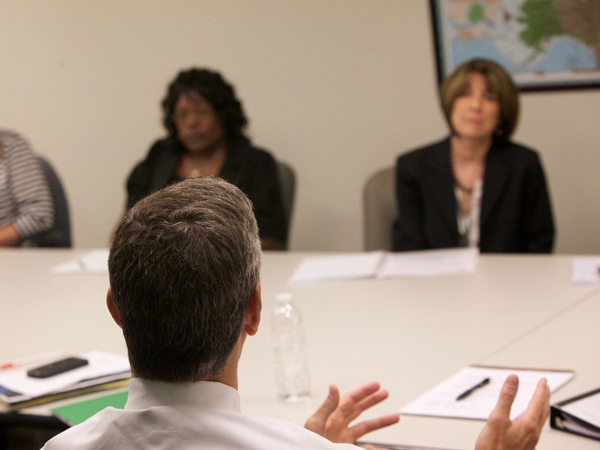 photo of a man talking to three women across a table