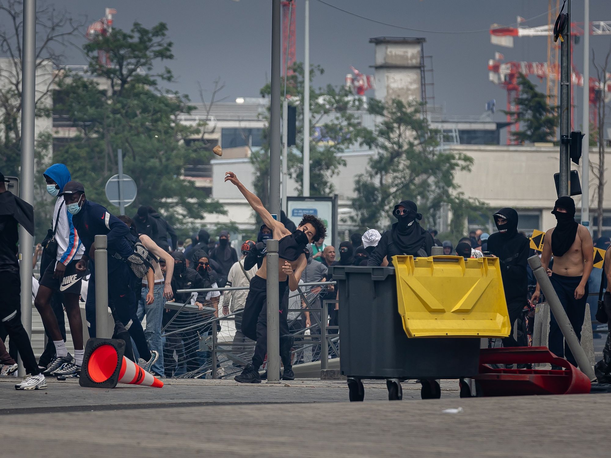 Photo of a man throwing a rock at police forces during a protest in Nanterre on June 29