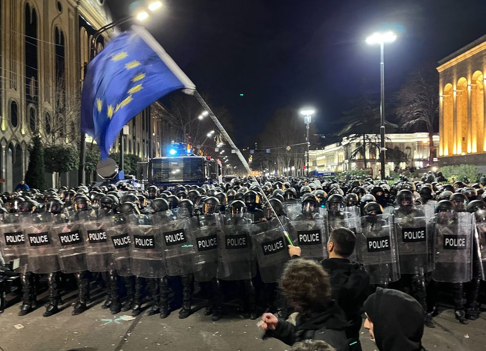 Photo of a man waiving a European flag in front of the police during the protests against the Foreign Agents Law in Tbilisi, Georgia, in March 2023.