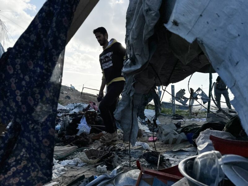 Photo of a man walking through rubble left by Israeli airstrikes in Khan Younis, Gaza