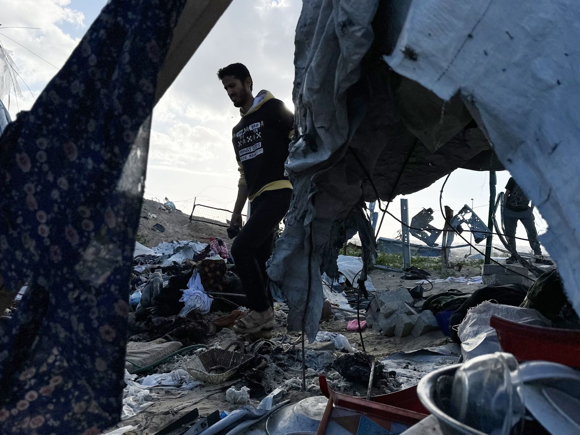 Photo of a man walking through rubble left by Israeli airstrikes in Khan Younis, Gaza