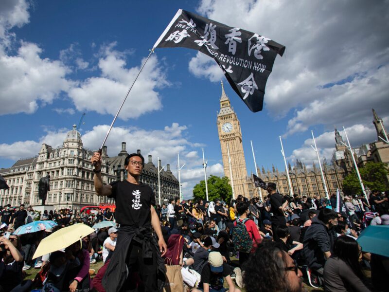 Photo of a man waving a flag during the anniversary of Hong Kong Protest in London