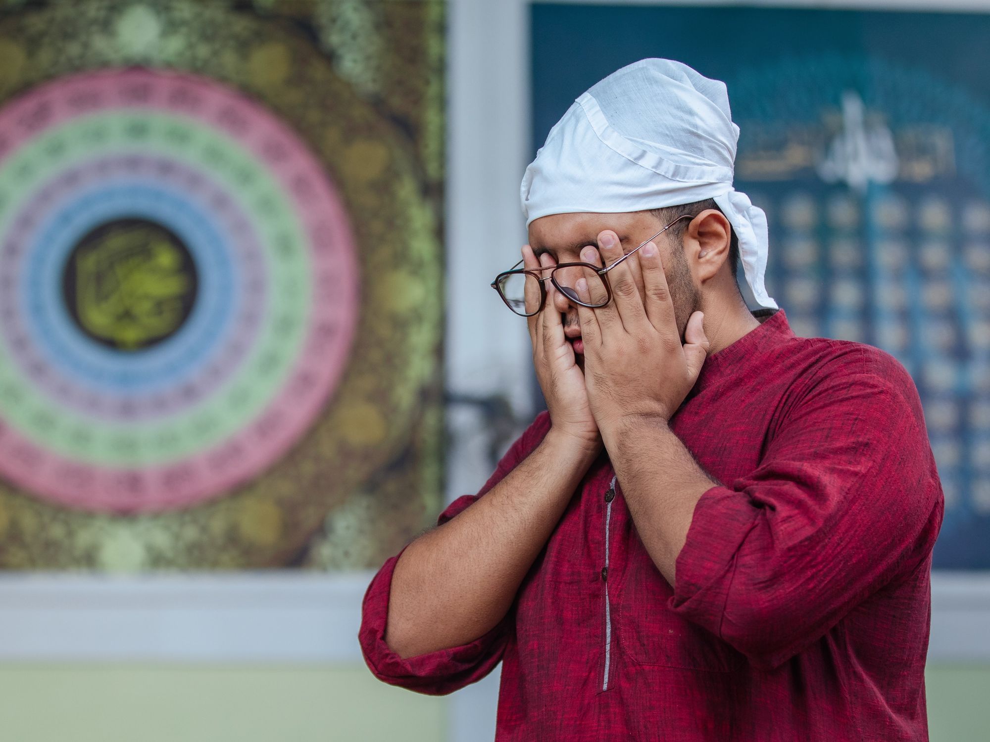Photo of a man wiping his face as he celebrates Eid al-Adha in Kathmandu, Nepal