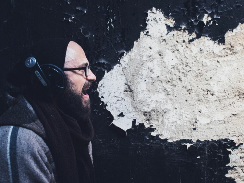 photo of a man yelling with white paint in background