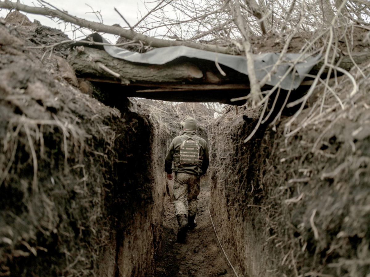 Photo of a member of Ukraine's 72nd Brigade walking in a trench, walking away from the camera