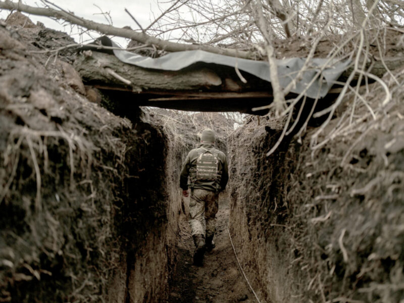 Photo of a member of Ukraine's 72nd Brigade walking in a trench, walking away from the camera