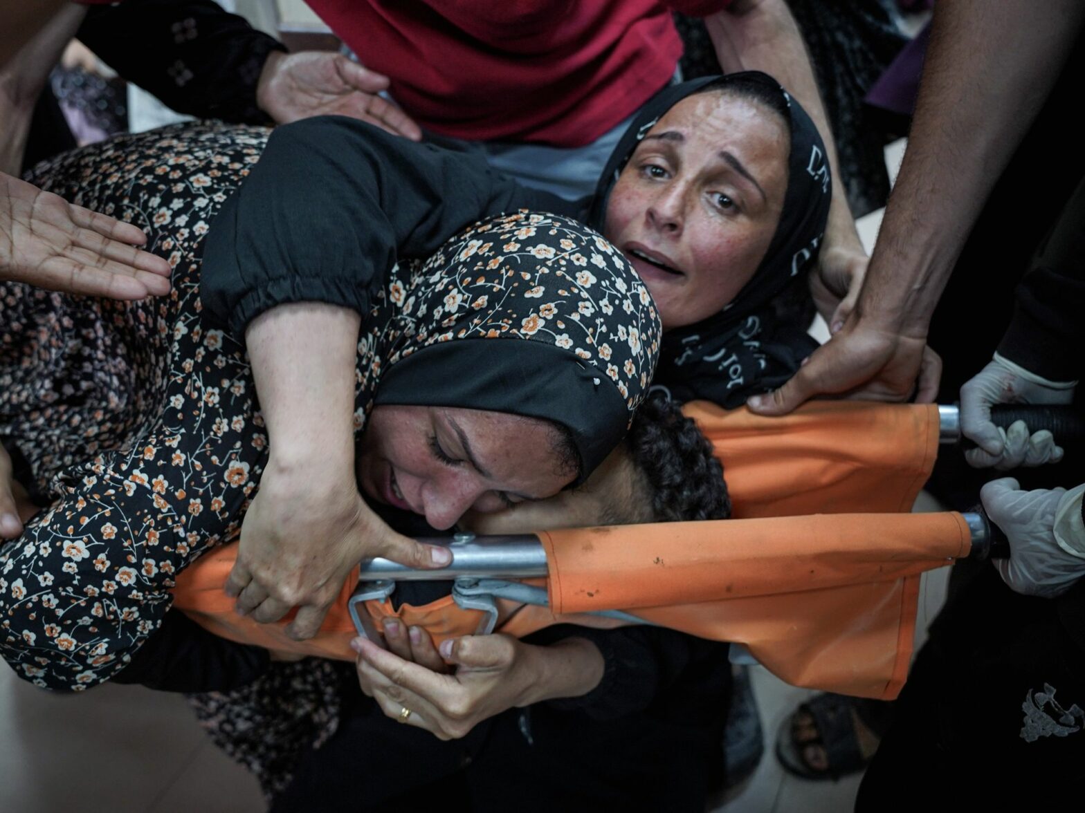 photo of a mother hugging her killed son on a stretcher