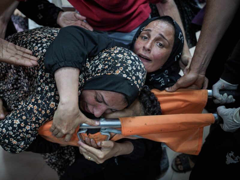 photo of a mother hugging her killed son on a stretcher