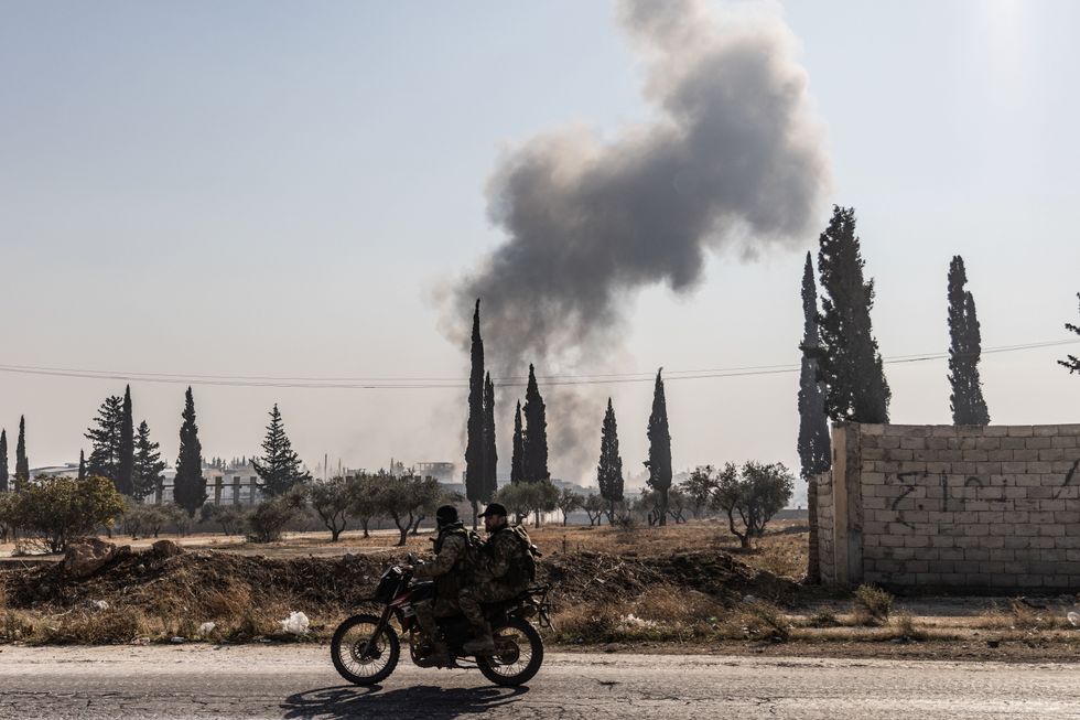 photo of a motorcycle with soldiers and smoke in the background