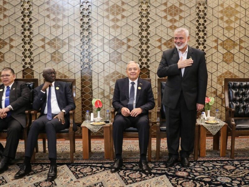 photo of a one man standing up and three sitting down.