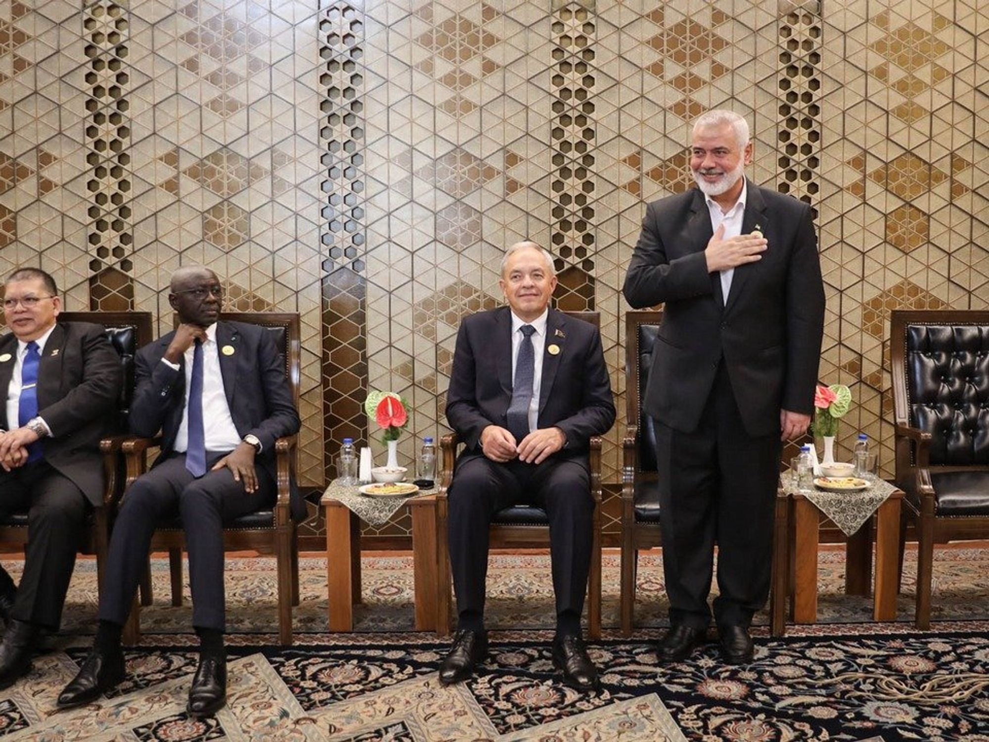 photo of a one man standing up and three sitting down.