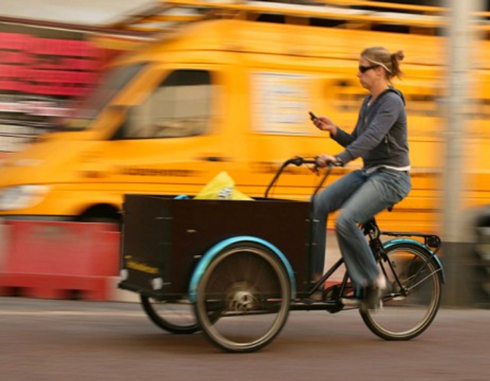 photo of a person driving while browsing her phone