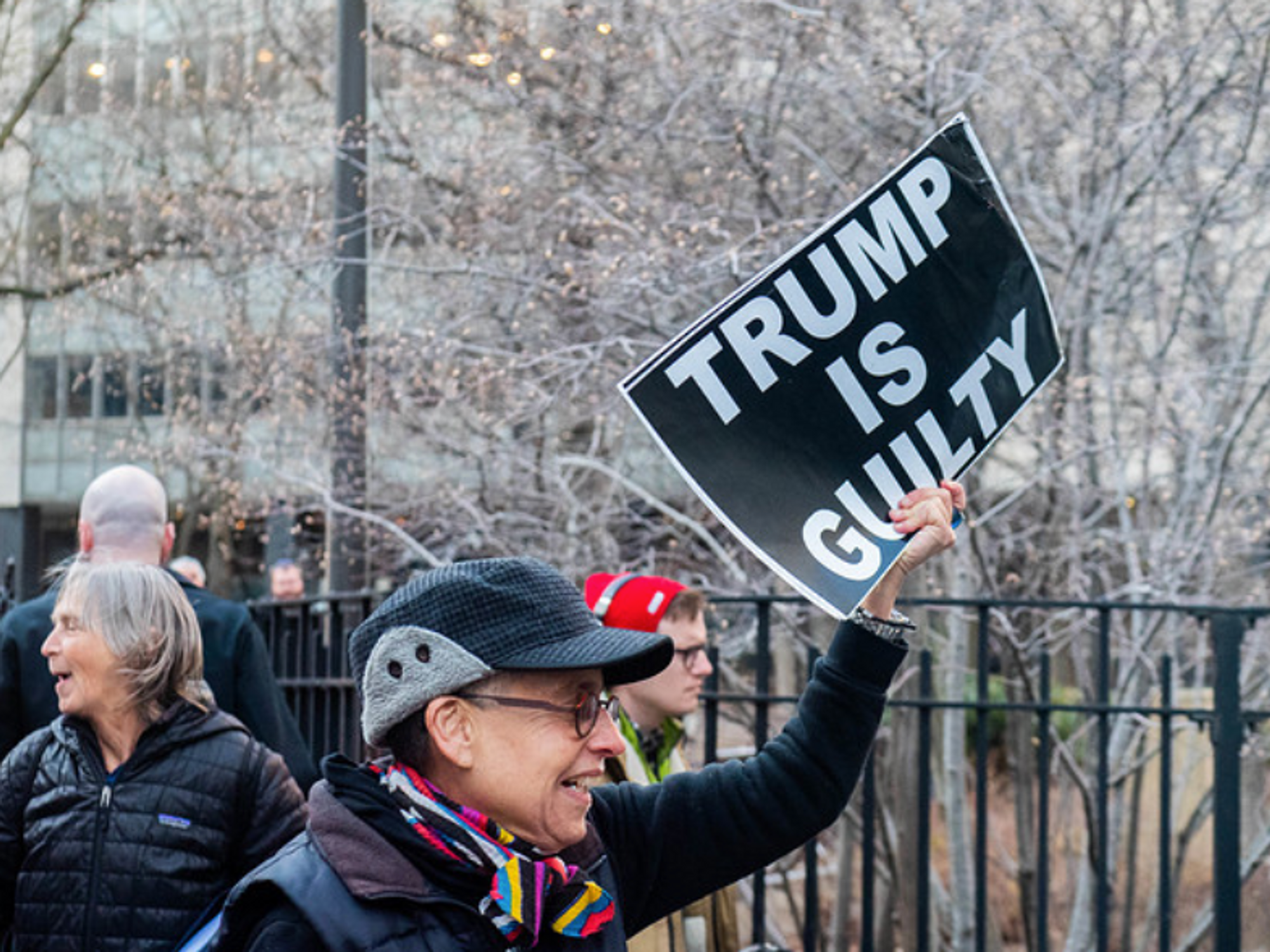 Photo of a person holding a sign that reads "TRUMP IS GUILTY" in New York on March 30