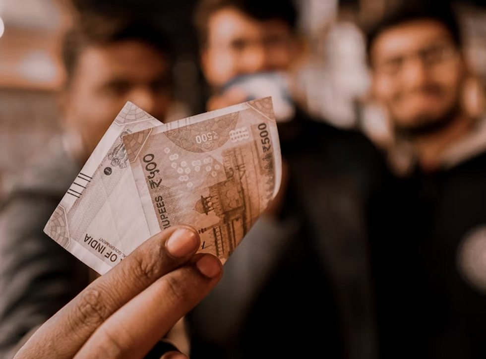 Photo of a person holding Indian banknotes