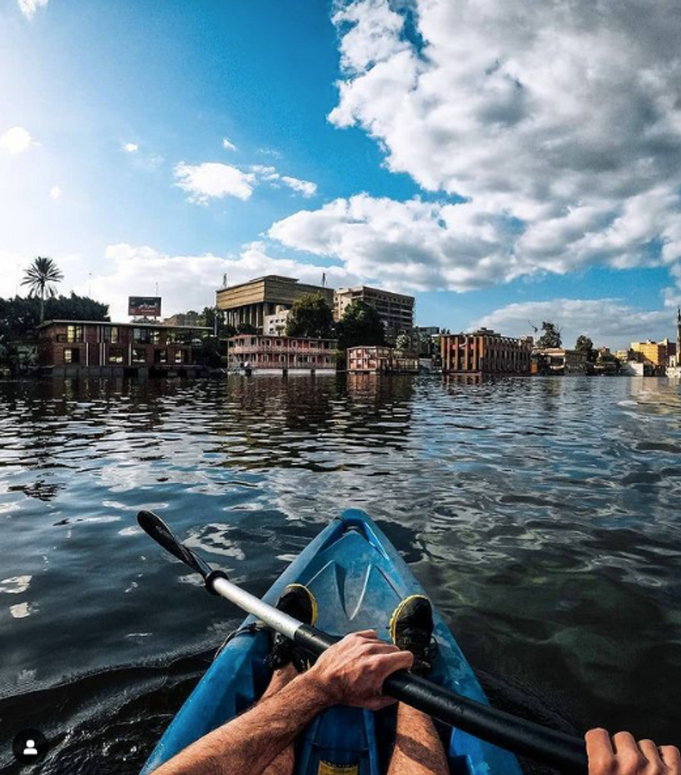 Photo of a person kayaking toward Cairo's houseboats​