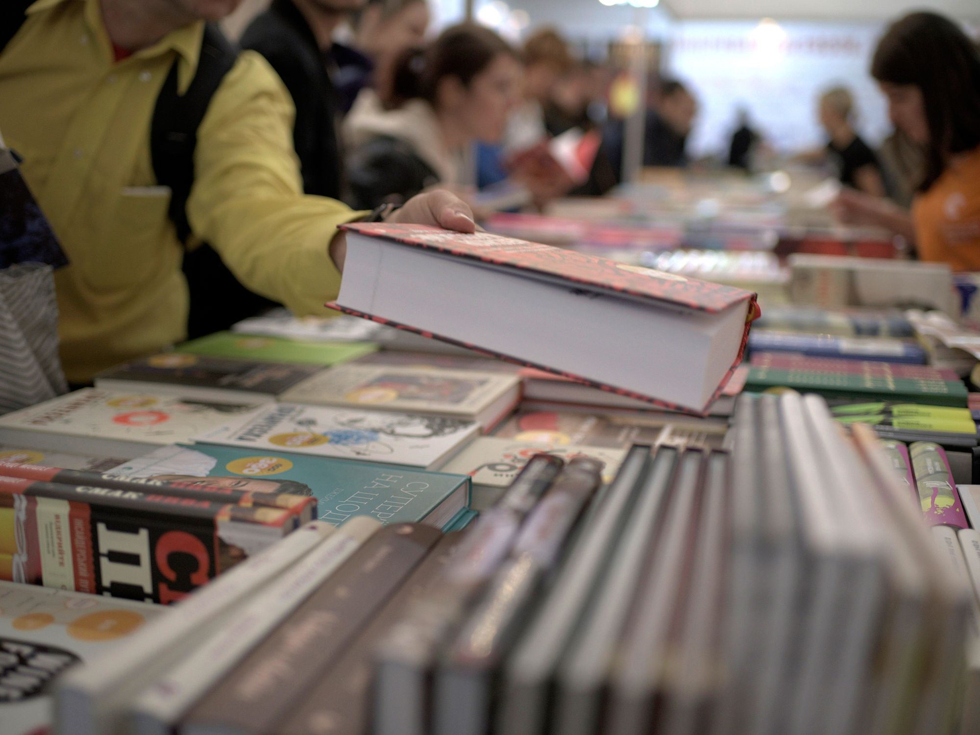 Photo of a person lifting a hefty book at a book fair in Lviv, western Ukraine