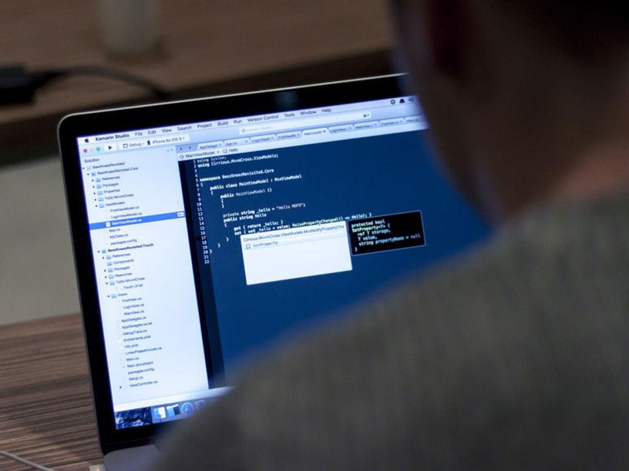 Photo of a person looking at lines of code on a laptop