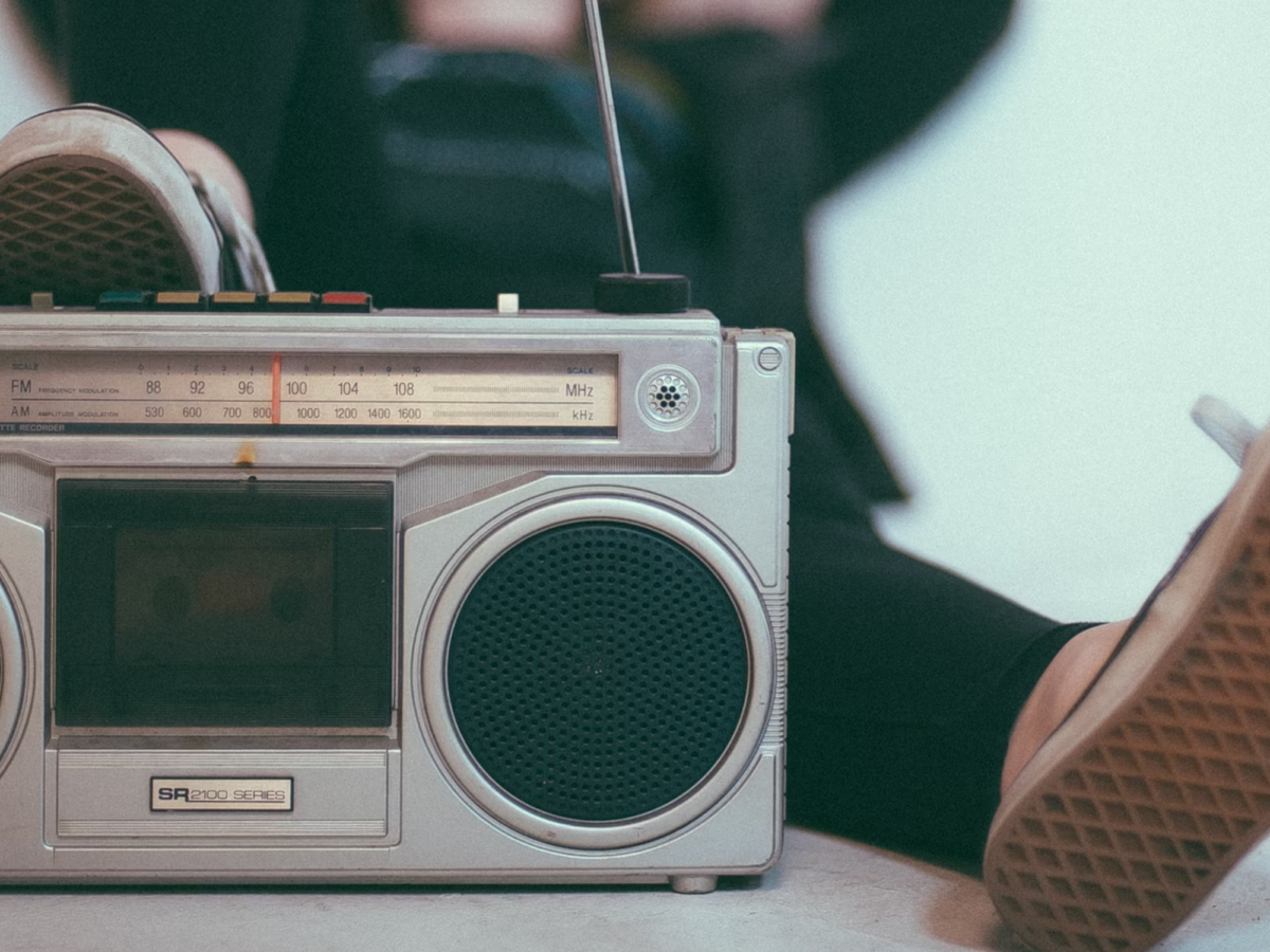 Photo of a person reclining while listening to a retro radio set