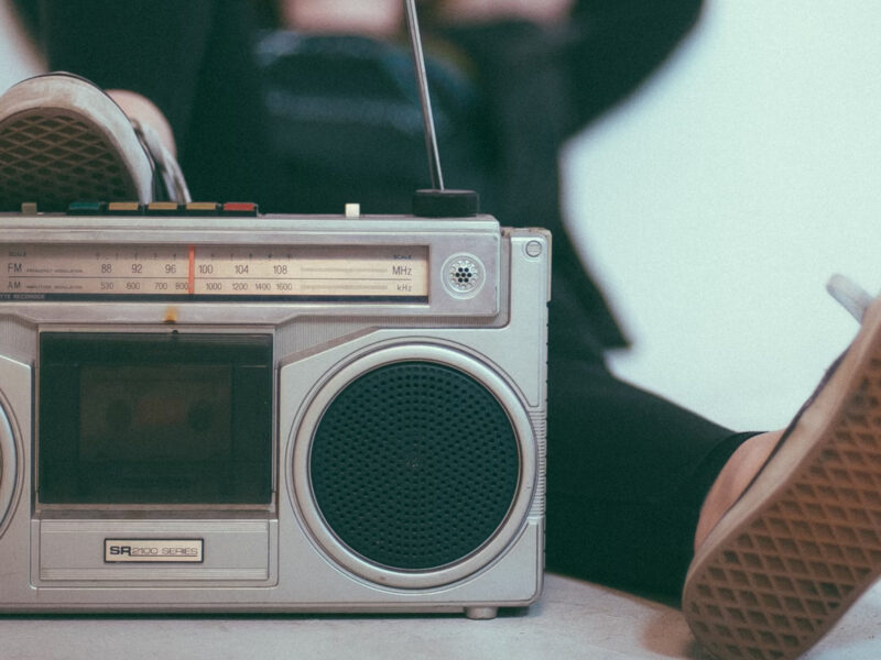 Photo of a person reclining while listening to a retro radio set