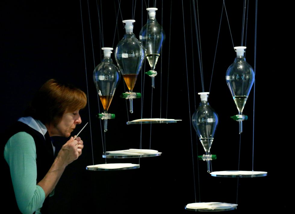 Photo of a person smelling the bottles with imaginary scents of the planets.