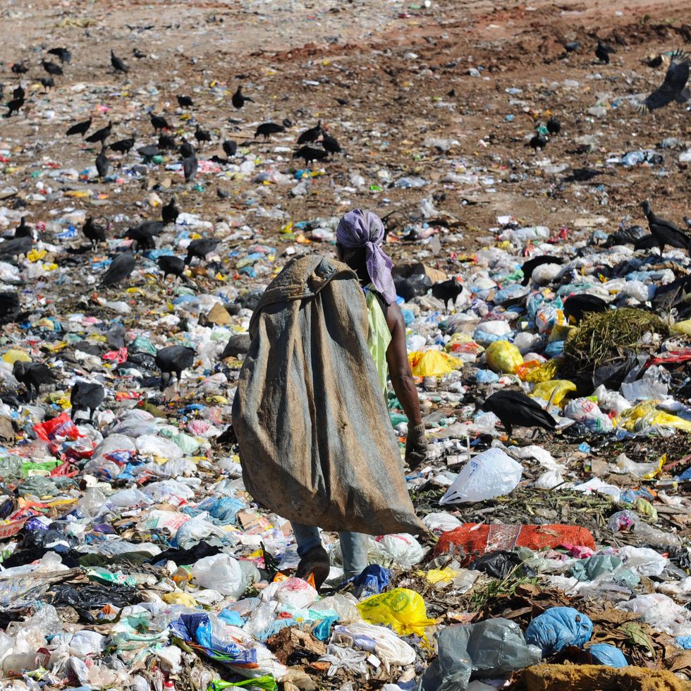 Photo of a person sorting out garbage in a landfill