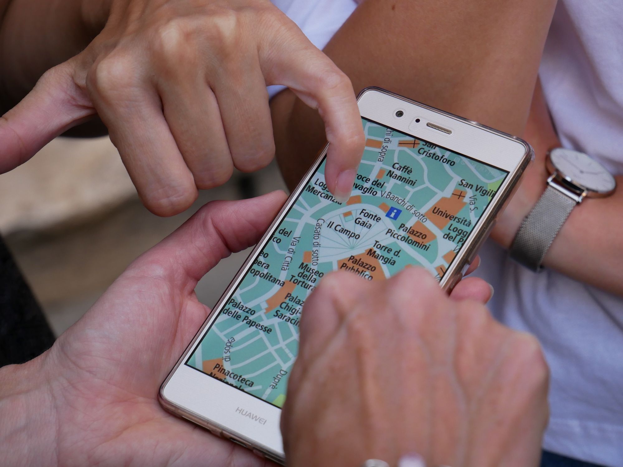 Photo of a person touching a map on smartphone.