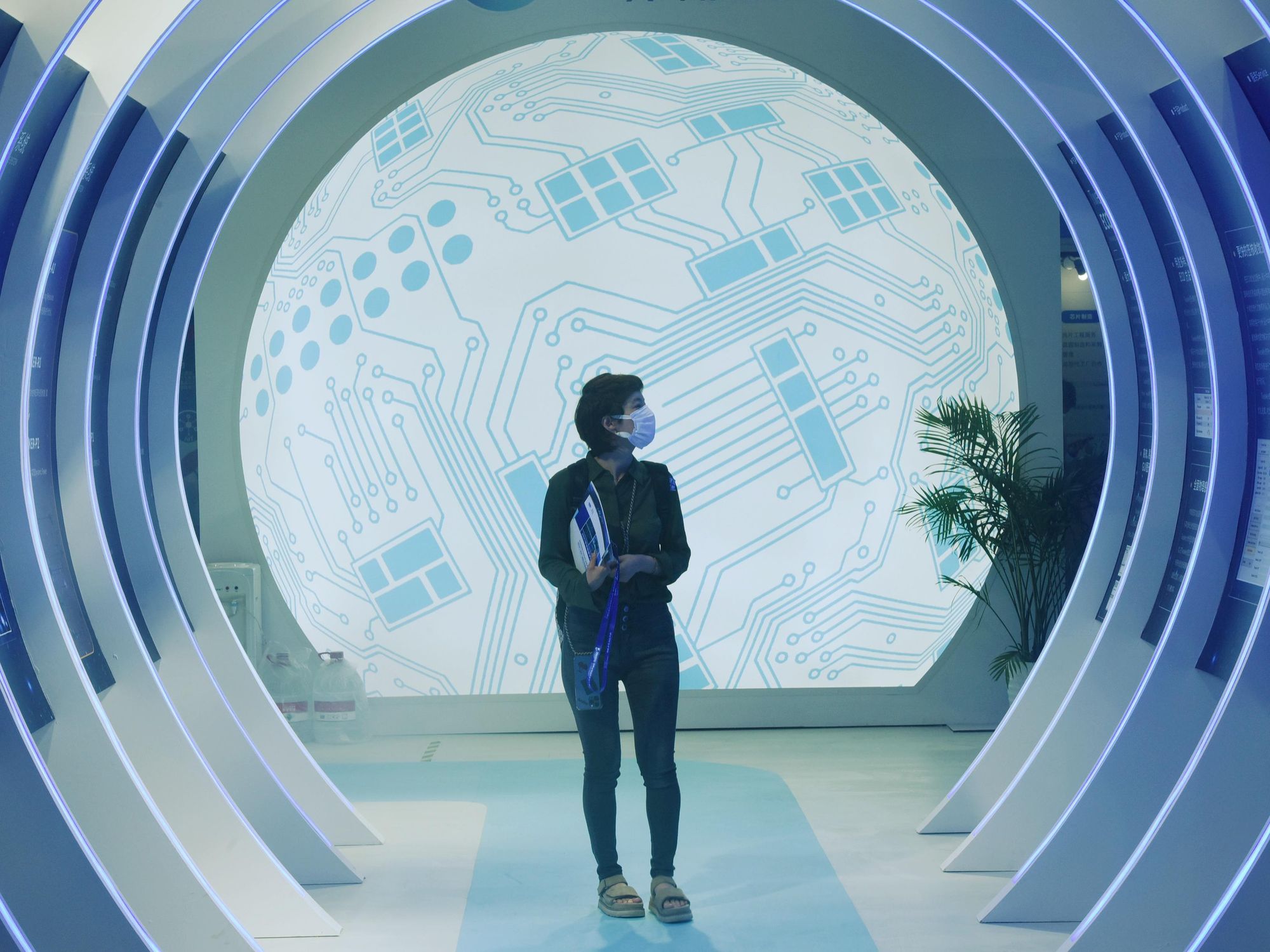 Photo of a person walking through a futuristic-looking corridor at the ​World Semiconductor Conference in Nanjing, China, on June 9