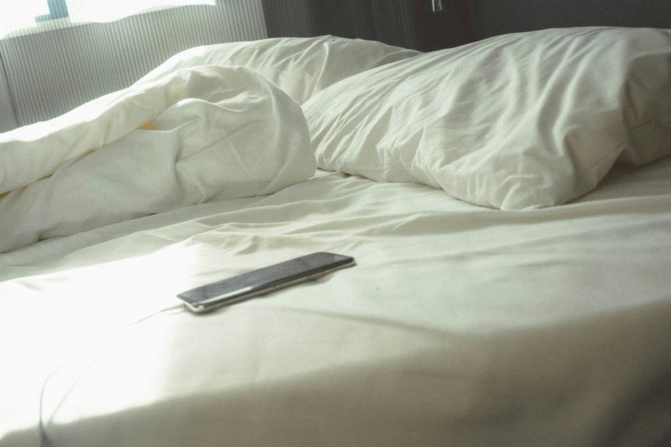 Photo of a phone charging on a bed