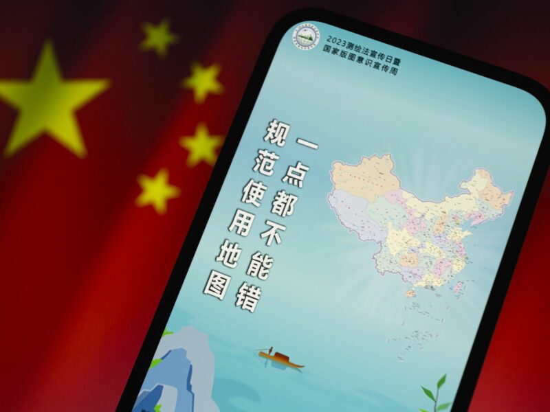 Photo of a phone showing the new controversial map of China, with a Chinese flag as a backdrop