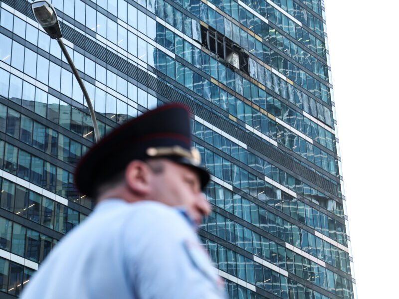Photo of a police officer in front of a building damaged by a drone attack in Moscow