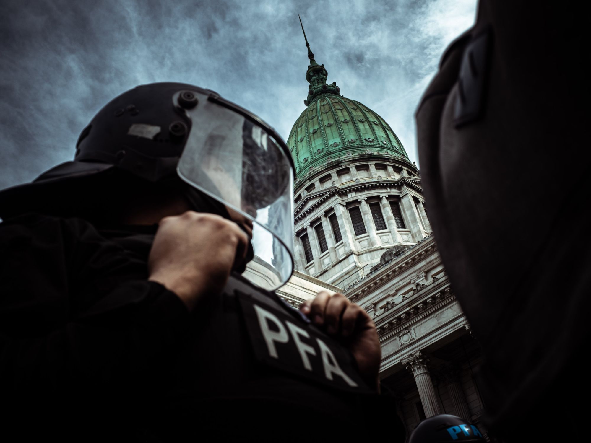 Photo of a police officer in front of the National Congress during the march against retirement law veto in Buenos Aires, Argentina.