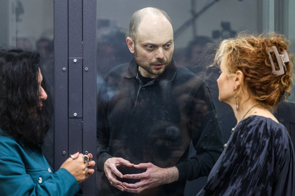 photo of a prisoner talking to his lawyers through the glass