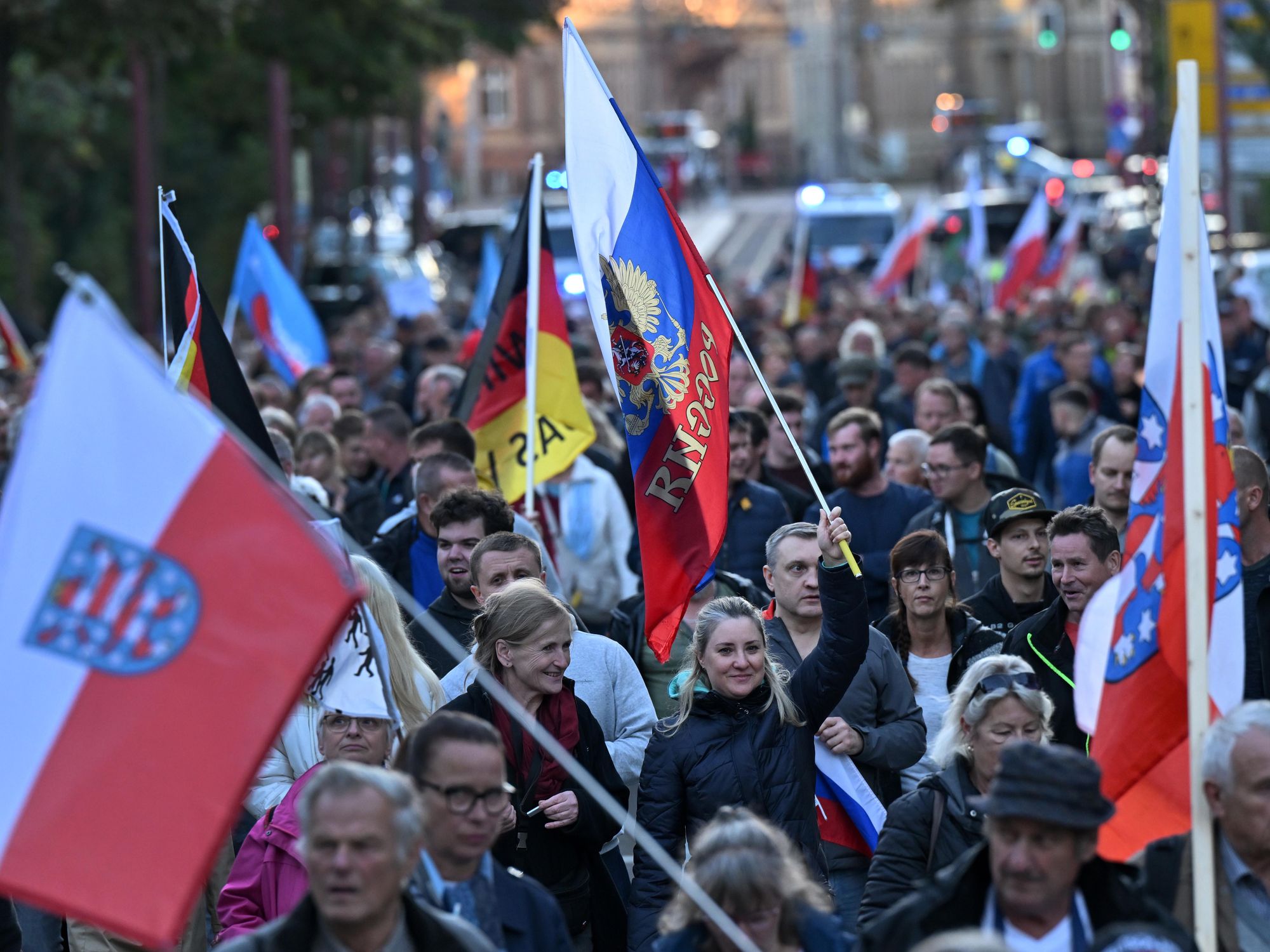 photo of a protest and people carrying Russian flags