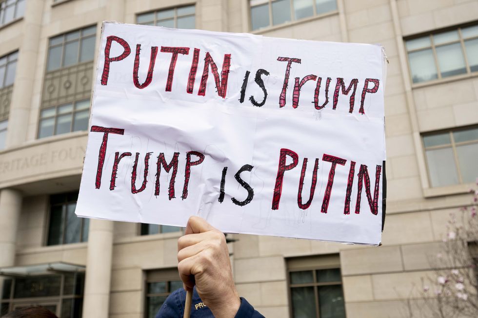 Photo of a protester brandishing a sign that reads "Putin is Trump, Trump is Putin" at an anti-Trump/Putin demonstration in Washington, D.C. on March 16.
