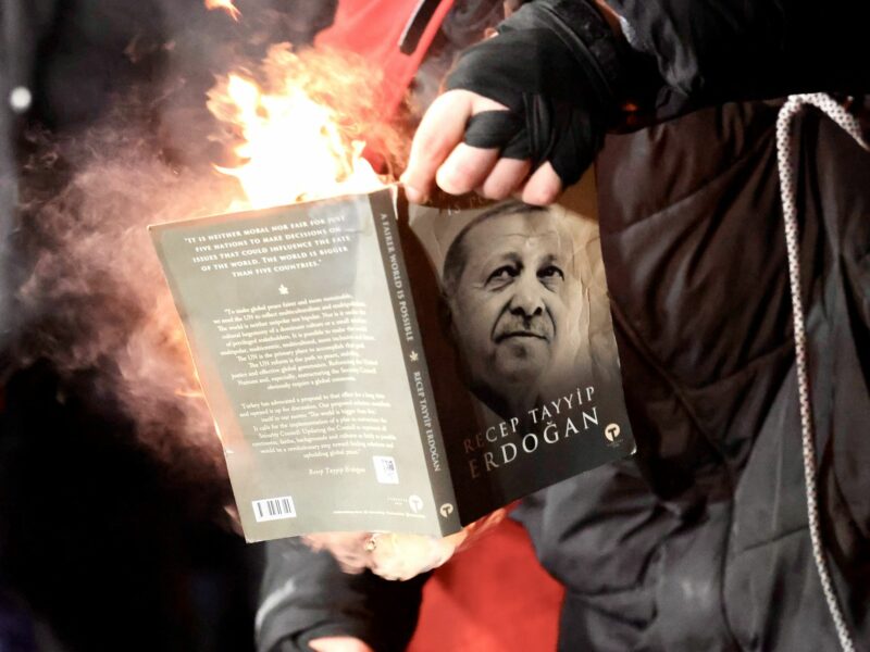 Photo of a protester lighting on fire a copy of a book with Erdogan's face on the cover, as part of protests in Istanbul on March 23.