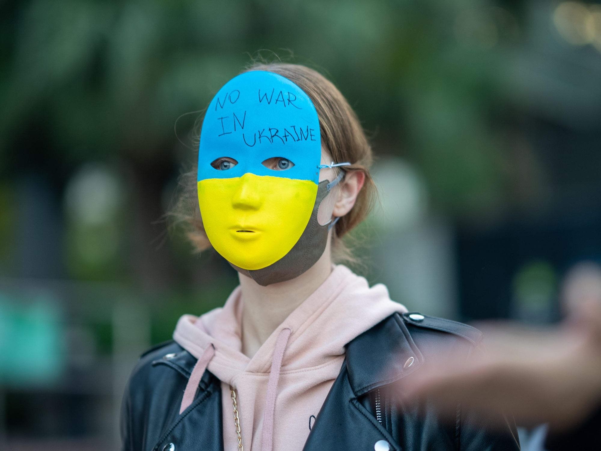 photo of a protester wearing a ukrainian flag mask