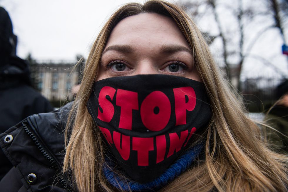Photo of a protestor wearing a mask that says STOP PUTIN