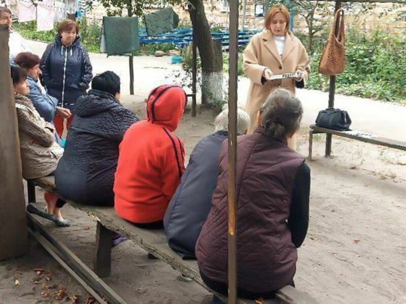 Photo of a psychologist speaking with trauma victims sat on a bench in a park