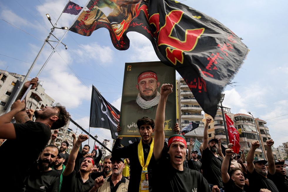 photo of a rally holding a photo of martyr