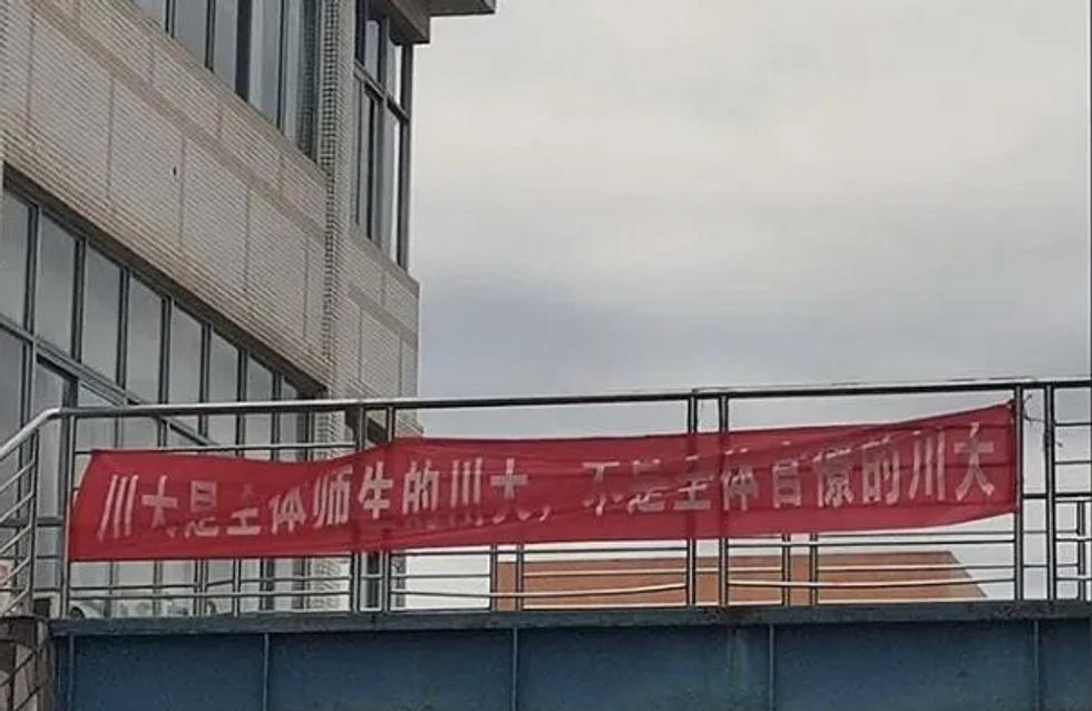 Photo of a red banner at Sichuan University (SCU) which reads “SCU is of its students and teachers, not bureaucrats”