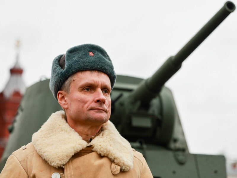 photo of a russian man in front of a tank