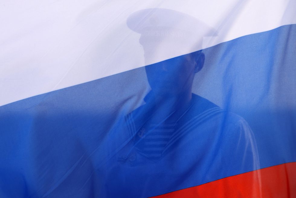 Photo of a Russian soldier behind a Russian flag